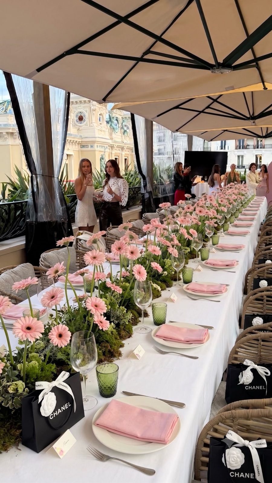Long terrace table with pink gerbera and moss centrepieces overlooking the Monte-Carlo Casino, by Kuration Studio